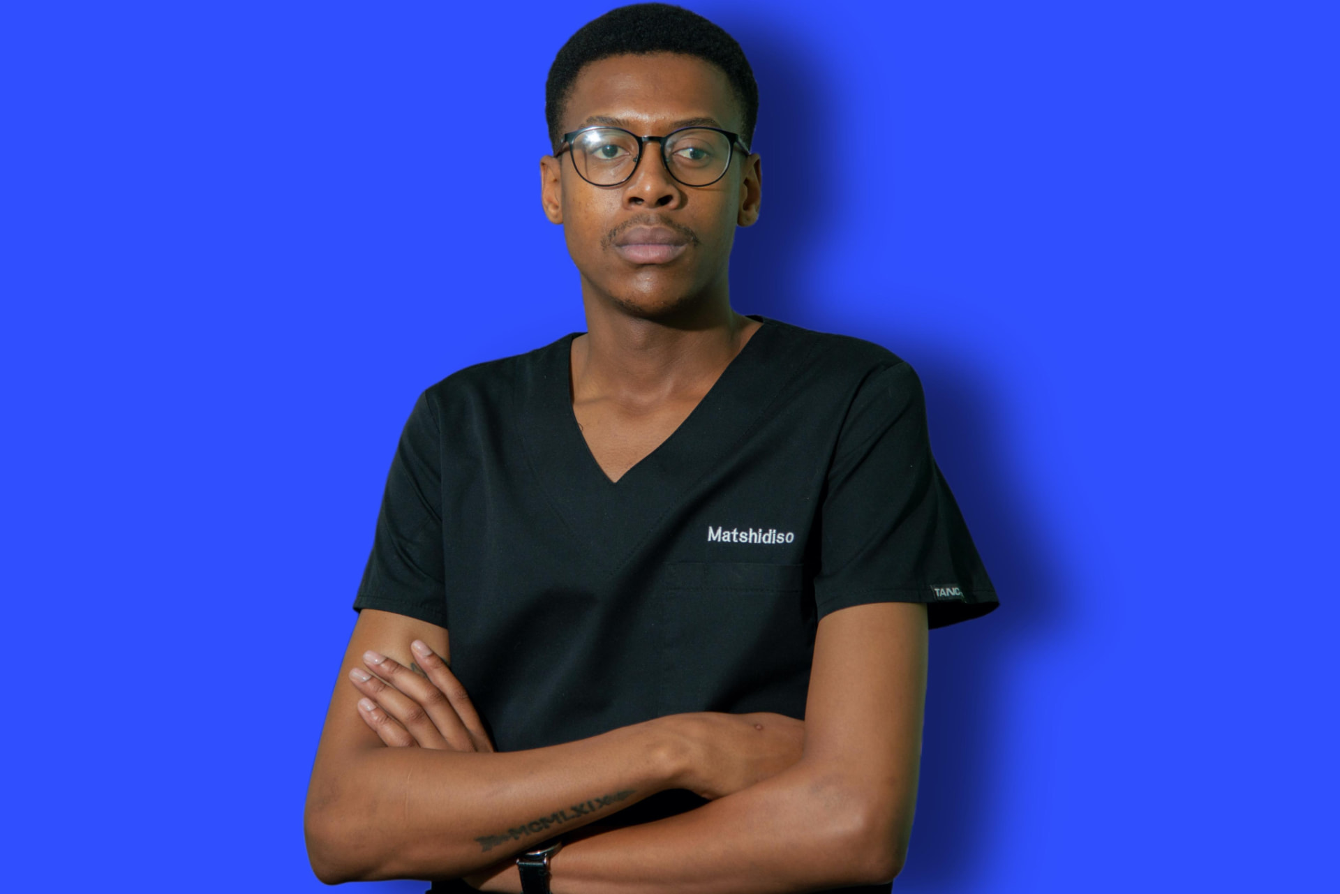 Matshidiso Setsetse, the administration and doctor's secretary at Dr T Matseke Practice, with arms crossed in black scrubs against a blue background